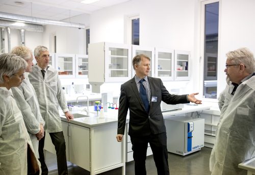 Mann viser rundt i hvitt laboratorium